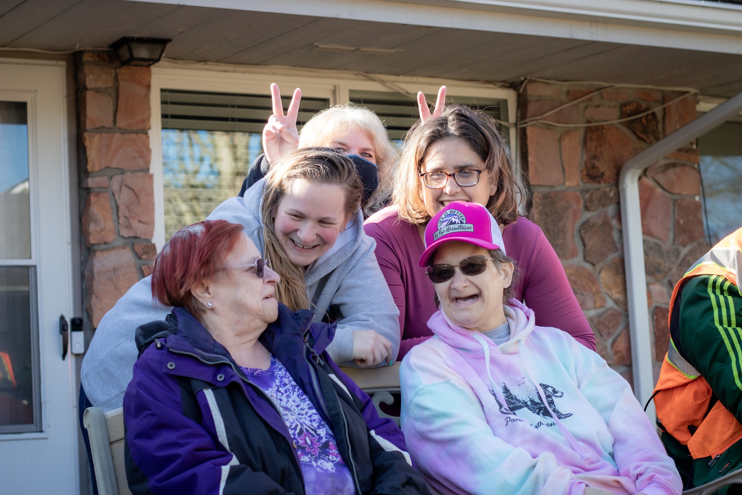 Group of women outside residential home laughing and smiling
