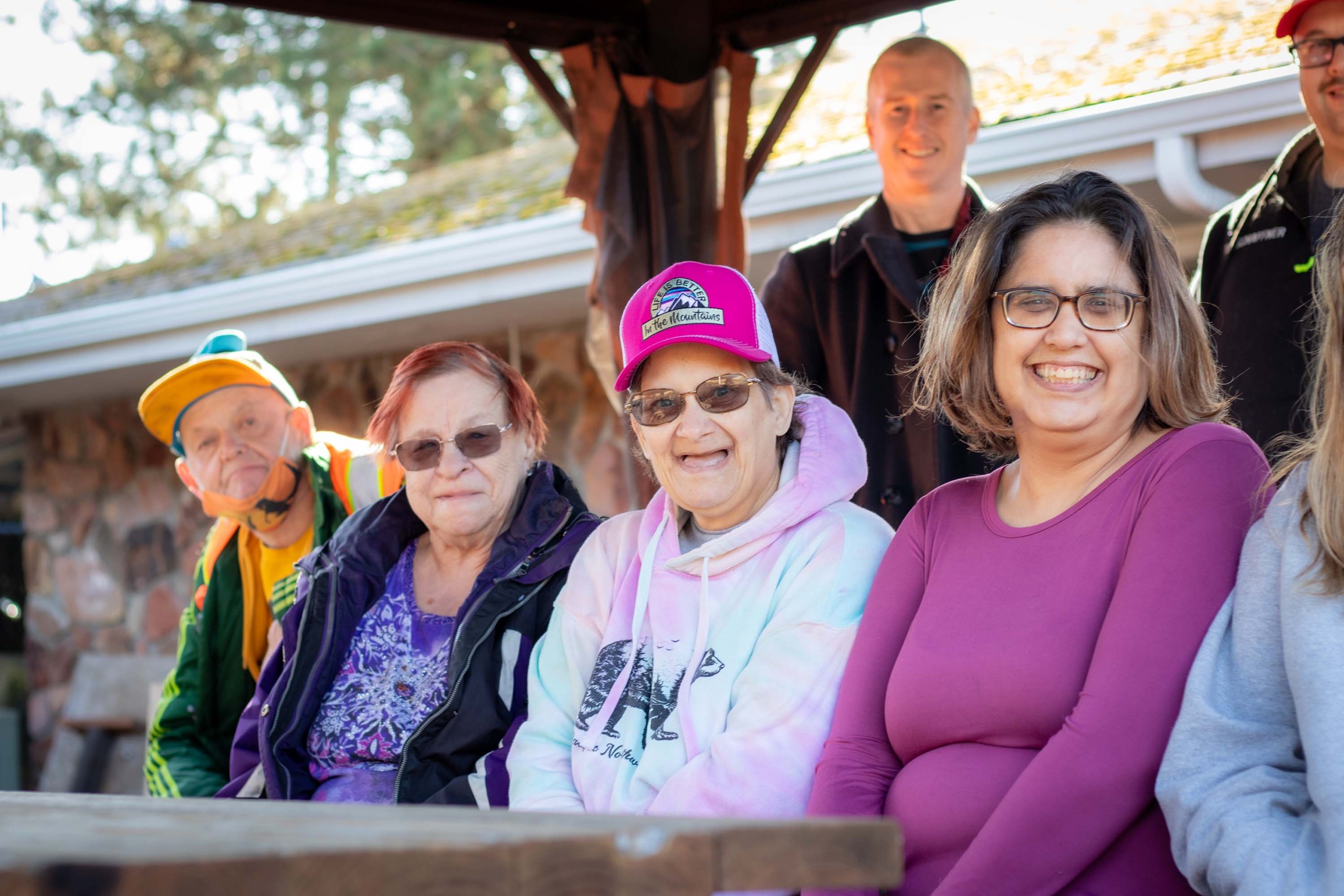 Group of MVA volunteers and the people they serve sitting together on a park bench