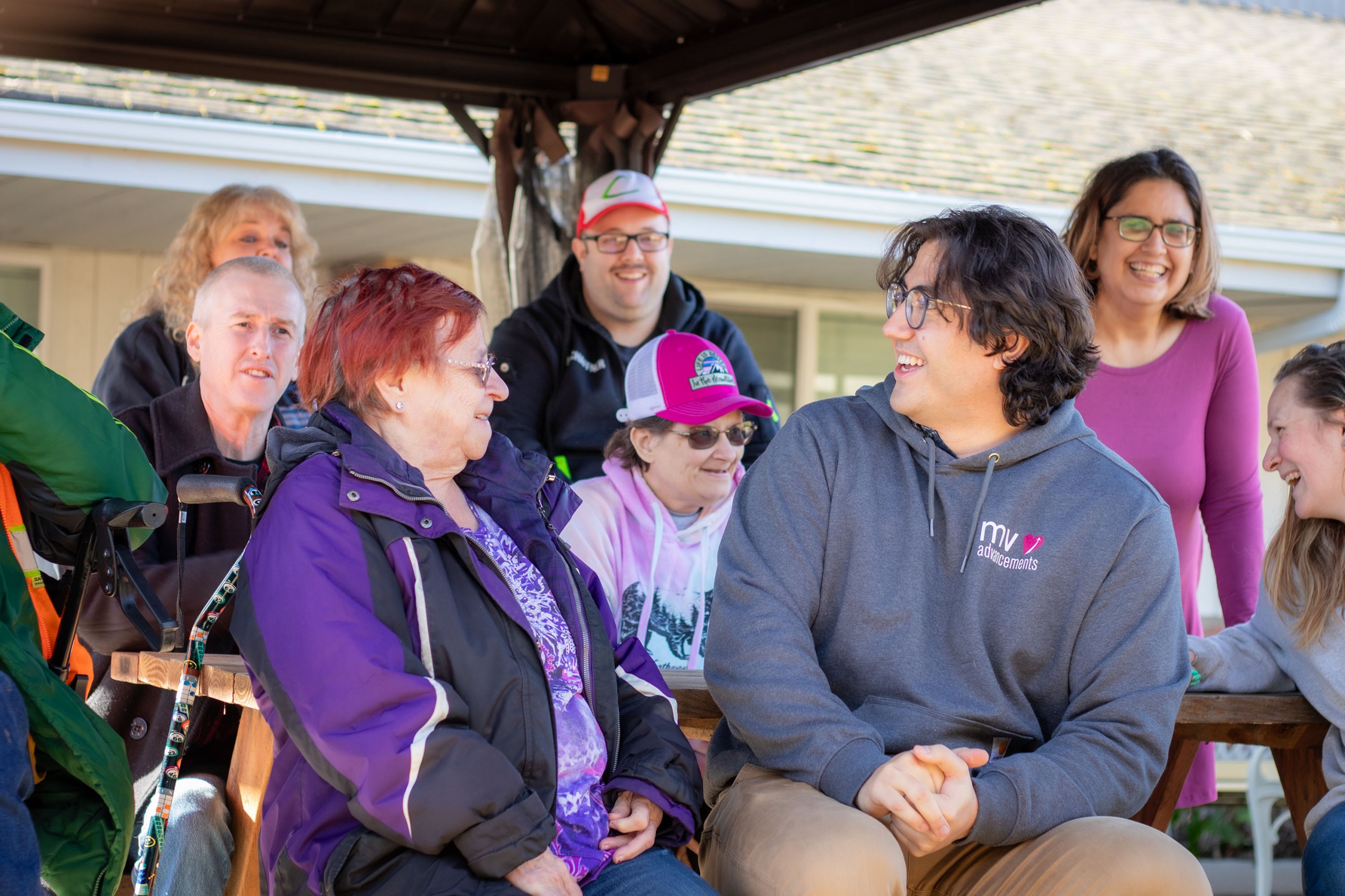 MVA group of volunteers and those they serve smiling and chatting at picnic table
